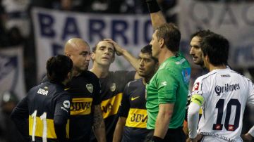 Santiago Silva (2do desde la izq.) de Boca Jrs, recibe la tarjeta roja por parte del juez central  Néstor Pitana en el juego ante Quilmes.