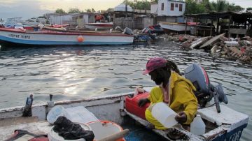 El pescador Daniel Edwards achica su bote de madera ayer en Port Royal, una aldea de pescadores a las afueras de Kingston, Jamaica.