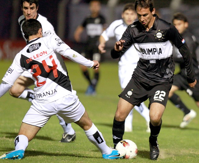 Julio Santa Cruz (der.) del Olimpia de Paraguay, disputa el balón con Gabriel De León (izq.) del Danubio de Uruguay durante el juego de ida que se saldó sin goles.