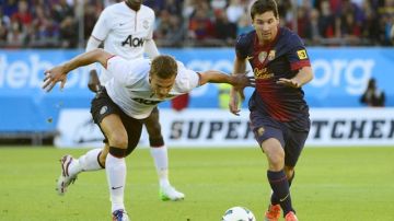 El delantero argentino Lionel Messi de Barcelona trata de escaparse de la marca de un rival del Manchester United, durante el cotejo amistoso en Göteborg.