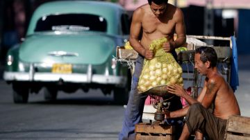 Carlos Alberto González, derecha y un amigo venden frutas en una calle de  La Habana (Cuba).