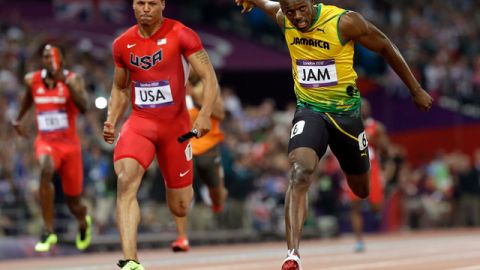 El atleta jamaiquino Usain Bolt cruza la meta adelante del estadounidens Ryan Bailey, para ganar el relevo 4x100 ayer en el Parque Olímpico.
