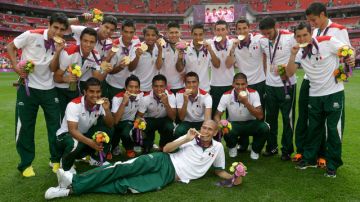 Los jugadores de la selección mexicana de fútbol posan con su medalla de oro ganada ayer en Londres, tras derrotar 2-1 a Brasil en el estadio Wembley.