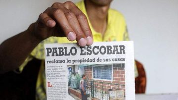 Wberney Zapata, líder comunitario del Barrio Pablo Escobar muestra recortes de prensa del mayor narcotraficante de la historia de Colombia.