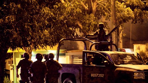 Soldados del Ejército mexicano caminan hacia sus vehículos después de encontrar siete cuerpos dentro de una camioneta en  Veracruz.