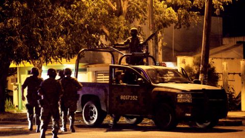 Soldados del Ejército mexicano caminan hacia sus vehículos después de encontrar siete cuerpos dentro de una camioneta en  Veracruz.