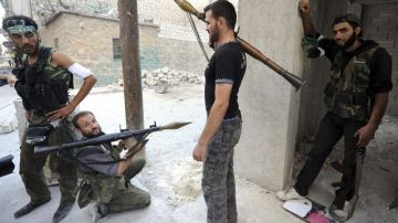 Rebeldes sirios vigilan su posición durante su lucha contra los seguidores de Bachar Al Asad en Alepo (Siria). En el fin de semana se produjeron más combates.