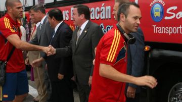 Víctor Valdés (izq.) y Andrés Iniesta (der.) saludan a funcionarios del gobierno de Puerto Rico al arribar ayer a la isla.