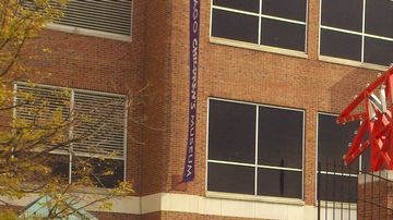 Imagen de jóvenes y sus familiares haciendo fila al aire libre en Navy Pier, en Chicago.