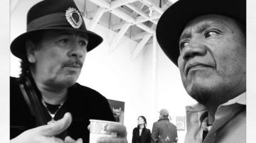 Carlos Santana y Calixto Robles intercambian ideas en Alley Cat Books.