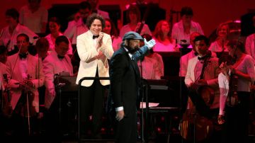 Juan Luis Guerra (centro) saluda a Gustavo Dudamel y la Filarmónica de Los Ángeles en el concierto del martes por la noche.