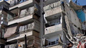 Un hombre camina frente a un edificio que quedó destruido tras los ataques que tuvieron lugar ayer en Alepo, Siria.