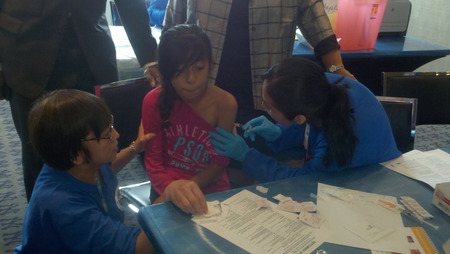 La niña Diana Reynoso, de 10 años, recibe sus vacunas contra la hepatitis A y la difteria en la jornada del año pasado en el estadio de los Yankees.