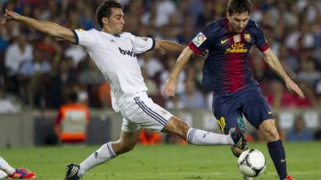 Leo Messi (d), del  Barcelona, lucha el balón con Álvaro Arbeloa, del Real Madrid, durante el partido de ida de la Supercopa.