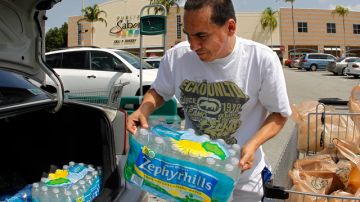 Carlos Eduardo Pérez carga botellas de agua en el maletero de su coche, mientras se prepara para la tormenta tropical Isaac,  en Hialeah, Florida. Todo el Caribe y parte de EstadosUnidos estaban ayer en emergencia.