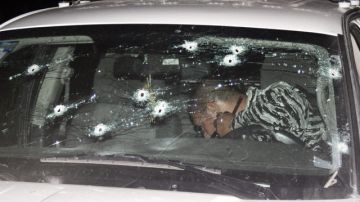 Policías especiales inspeccionan  un vehículo tras un enfrentamiento con miembros del crimen organizado.