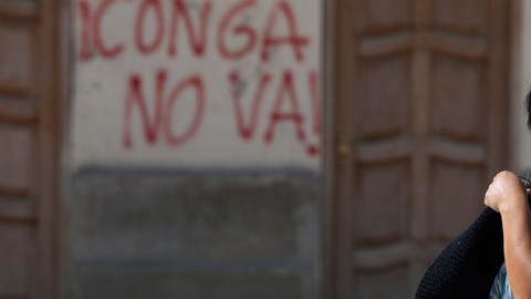 Un manifestante descansa cerca de un muro pintado con las palabras "Conga no va  a ocurrir" durante una protesta.