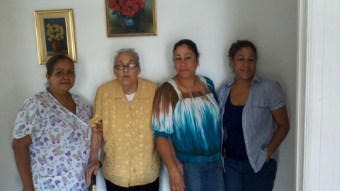 La envejeciente Josefina Ovalle (segunda a la izq) junto a su cuidadora Madelín y sus hijas gemelas Elizabeth y Grace Ovalle. A la izquierda, el frente del edificio ubicado en el 450 de la avenida Audubon, que pasó a manos de una Administración de la Corte por problemas de falta de mantenimiento.