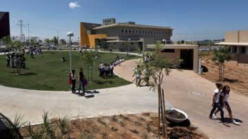 Estudiantes caminan en el campus de una escuela, próximos a un edificio escolar a prueba de mísiles,  en Sderot, Israel, ayer.