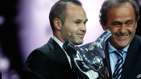 Andrés Iniesta recibe el trofeo de la UEFA a manos de Michel Platini, tras el sorteo de la Liga de Campeones en el Fórum Grimaldi.