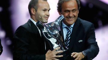 Andrés Iniesta recibe el trofeo de la UEFA a manos de Michel Platini, tras el sorteo de la Liga de Campeones en el Fórum Grimaldi.