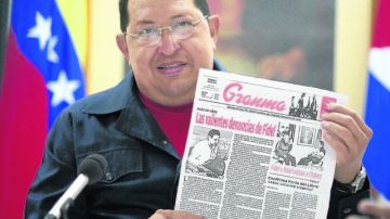 El presidente Hugo Chávez con el periódico cubano Granma en sus manos.