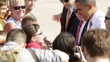 El presidente Barack Obama saluda a unos simpatizantes tras su arribo al aeropuerto de  Sioux City, Iowa, donde  inicia una gira como parte de su campaña de reelección.