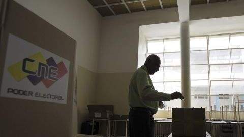 Un hombre deposita su voto en una urna durante el ensayo general previo a las elecciones presidenciales, en Venezuela.