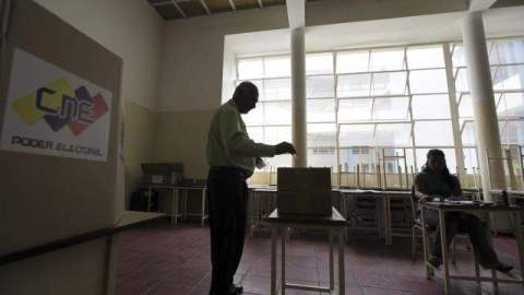 Un hombre deposita su voto en una urna durante el ensayo general previo a las elecciones presidenciales, en Venezuela.