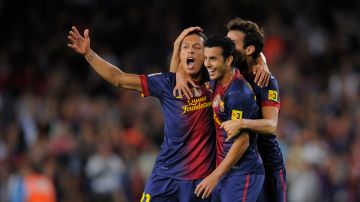 Adriano (izq.) es felicitado por sus compañeros Xavi y Pedro, después de anotar ayer contra el Valencia en el Camp Nou.