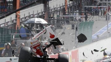 El Ferrari de Fernando Alonso (izq.) se eleva al ser impactado por el McLaren Mercedes de Lewis Hamilton (derecha) en la carrera de ayer.