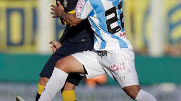 Pablo Ledesma (izq.), del Boca, lucha por la bola con Raul Ferro (der.) del Atlético Rafaela durante el partido dominical que cambió el liderato en Argentina.