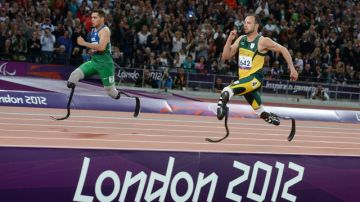 El brasileño  Alan   Oliveira (izq.) supera al sudafricano Oscar Pistorius (der.) en la controversial carrera de los 200 metros de los Juegos Paralímpicos.