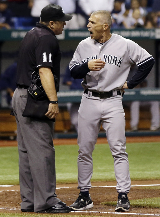 El piloto de los Yankees Joe Girardi (derecha) discute con el árbitro principal Tony Randazzo en la cuarta entrada del juego de ayer contra los Rays en Tampa Bay. Minutos después, Girardi fue expulsado.