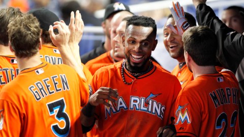 El dominicano José Reyes (centro) es felicitado por sus compañeros tras anotar una carrera para los Marlins de Miami en la primera entrada del juego de ayer.