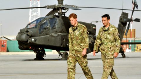 El príncipe Enrique pasa por delante de la línea de vuelo de un Apache en Camp Bastion, en Afganistán, donde estará operando como artillero copiloto.