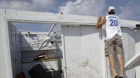 El dueño de una cabaña que quedó sin techo en el Club de Surf Breezy Point, en Nueva York, revisa los daños causados por un tornado.