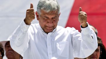 López Obrador hace una señal de victoria a sus seguidores, que se  reunieron ayer en El Zócalo.