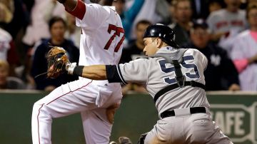 Pedro Ciriaco de los Red Sox celebra ante Russell Martin de los Yankees la carrera de la victoria.