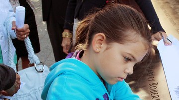 En el marco de las ceremonias con motivo del décimo primer aniversario de los atentados del 11 de septiembre del 2001, una niña  deja un mensaje en la pared donde se encuentran los nombres de las personas que murieron en los atentados de  Nueva York.