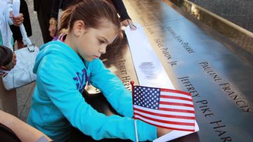 En el marco de las ceremonias con motivo del décimo primer aniversario de los atentados del 11 de septiembre del 2001, una niña  deja un mensaje en la pared donde se encuentran los nombres de las personas que murieron en los atentados de  Nueva York.