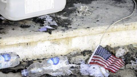 Una bandera de EEUU permanece en el suelo frente a restos carbonizados en el edificio del consulado estadounidense en Bengasi (Libia).