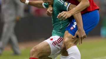 El delantero Javier "Chicharito" Hernández (izq.), autor del gol del triunfo de México, es marcado a presión por el jugador  tico Jhonny Acosta.
