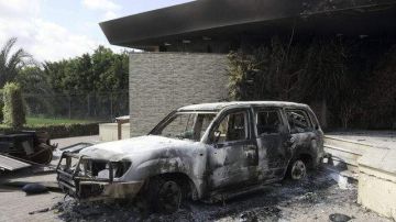 Vista de los restos carbonizados de un vehículo en el edificio del consulado estadounidense en Bengasi (Libia). En el círculo el embajador Chris Steven.