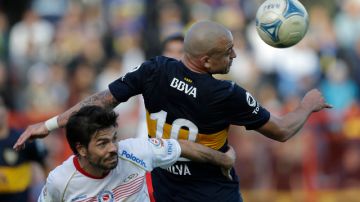 Santiago Silva de Boca rechaza ante la marcación de Ariel Garce de Argentinos Juniors durante la fecha anterior que terminó 1-1.