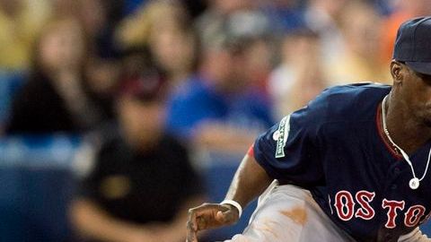 Pedro Ciriaco de los Medias Rojas de Boston deja fuera de juego a Brett Lawrie de Toronto en tercera base.