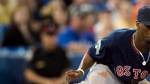 Pedro Ciriaco de los Medias Rojas de Boston deja fuera de juego a Brett Lawrie de Toronto en tercera base.