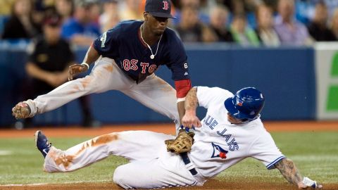 Pedro Ciriaco de los Medias Rojas de Boston deja fuera de juego a Brett Lawrie de Toronto en tercera base.
