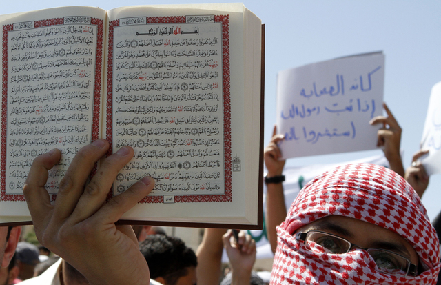 Un manifestante muestra el  Corán durante una protesta  en Amman, Jordania.