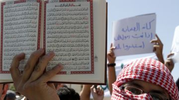 Un manifestante muestra el  Corán durante una protesta  en Amman, Jordania.